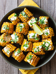 Grilled corn with white sauce and herbs. BBQ. Picnic. Vegetarian food. Diet.