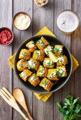 Grilled corn with white sauce and herbs. BBQ. Picnic. Vegetarian food. Diet.