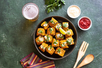 Grilled corn with white sauce and herbs. BBQ. Picnic. Vegetarian food. Diet.
