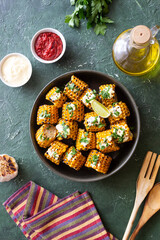 Grilled corn with white sauce and herbs. BBQ. Picnic. Vegetarian food. Diet.