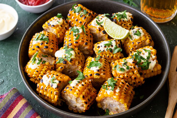 Grilled corn with white sauce and herbs. BBQ. Picnic. Vegetarian food. Diet.