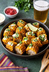 Grilled corn with white sauce and herbs. BBQ. Picnic. Vegetarian food. Diet.