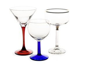 Isolated empty drinking glasses on white background, set of wine or sherry, champagne and cocktail glasses with colored stems on white, copy space 