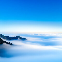 Obraz premium A breathtaking view of mountains emerging from a sea of fog under a bright blue sky, showcasing nature's serene beauty.