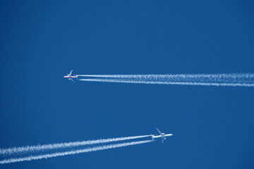 Airplane in the blue sky with contrail. Two planes in the sky.