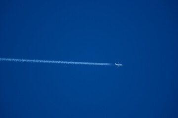 Airplane in the blue sky with contrail. Private jet in the blue sky.