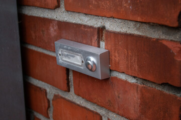 Close up of a simple house doorbell on a bricks wall near the front door