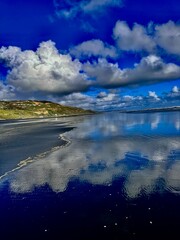 Serene coastal reflection under a blue sky