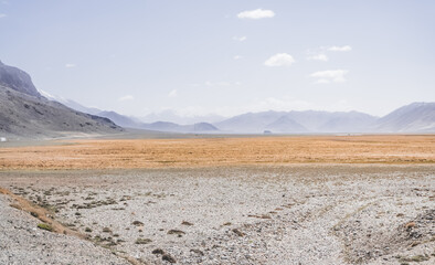 Mountain range of rocks covered with snow in highlands of Tien Shan in Pamir in Tajikistan, panoramic landscape of snowy mountain range and hills for background