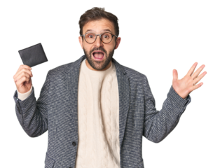 Hispanic male with briefcase in studio receiving a pleasant surprise, excited and raising hands.