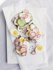 Open-Faced Sandwiches with Egg, Radish, and Cucumber on Sourdough bread, on white background
