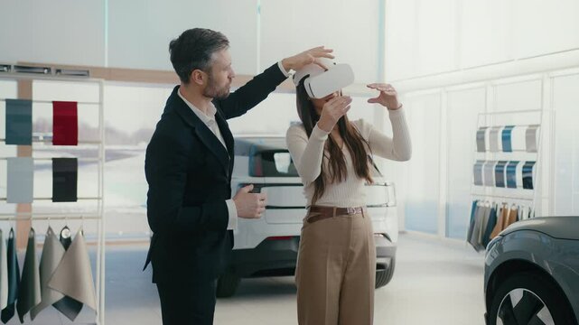 Manager providing innovative method for selecting auto. Potential client using VR headset while choosing vehicle. Learning information about car model with high-tech. Modern customer interaction.