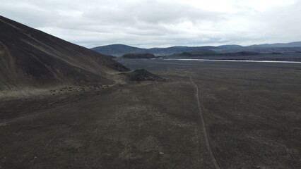 Vue aérienne au drone professionnel d’une voiture en Islande sur route désertique volcanique...
