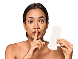 Filipino woman with sanitary pad in studio keeping a secret or asking for silence.