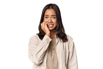 Portrait of a young Filipino woman biting fingernails, nervous and very anxious.