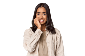 Portrait of a young Filipino woman biting fingernails, nervous and very anxious.