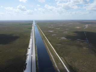 Vue aérienne au drone professionnel du parc naturel Everglades avec suivi d’un airboat sur rivière, Floride, USA
