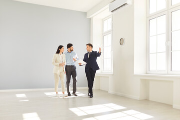 Realtor presenting, licensed real estate agent, salesperson advertising property to couple family,...
