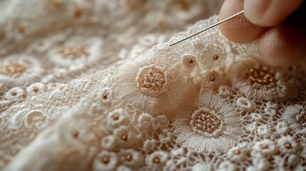 Intricate hand embroidery on delicate lace fabric showcases skillful craftsmanship