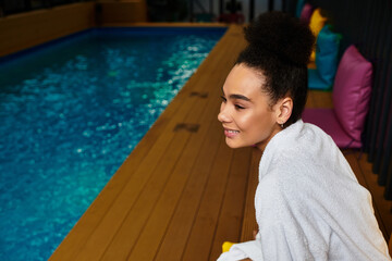 Young woman enjoys serene moments by a tranquil spa pool for ultimate relaxation and wellness