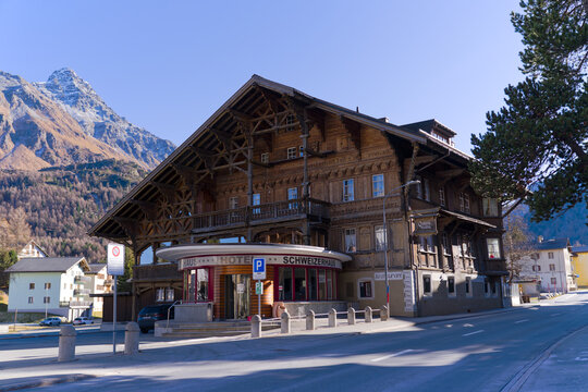 Wooden chalet hotel and restaurant named Schweizerhaus at Swiss mountain village of Maloja on a sunny autumn day. Photo taken November 15th, 2024, Maloja Bregaglia, Switzerland.