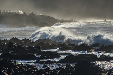 cresting waves between rocks