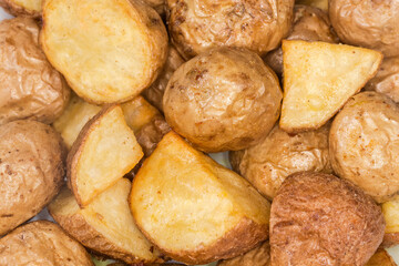 Pieces of potato baked peasant style, top view close-up