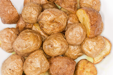 Pieces of potato baked peasant style on dish, top view
