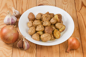 Pieces of potato baked in peasant style on rustic table