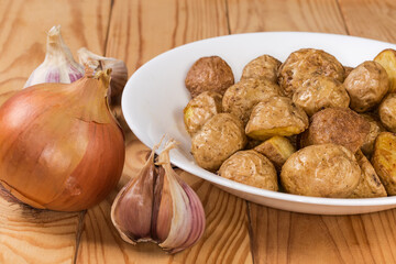 Pieces of potato baked in peasant style on rustic table