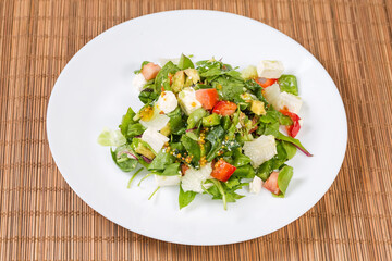 Salad with diced mozzarella and fresh vegetables, different leaf lettuce