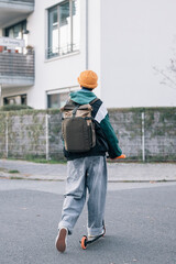 Modern student enjoying the way to school using a scooter