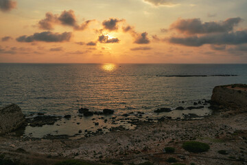 Fototapeta premium Rocky Shoreline at Methoni Fortress During Sunset