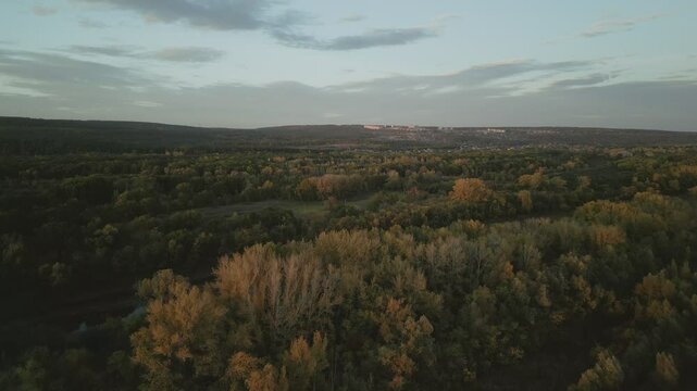 Autumn landscape with river and forest at sunset