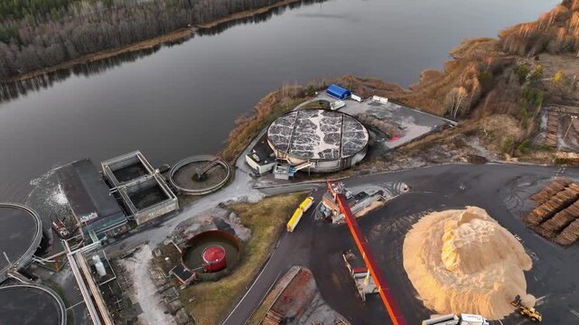 Crane loading wood chips at lakeside industrial facility