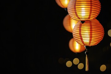 Fototapeta premium Warm, glowing paper lanterns illuminated at night, evoking a festive and cultural atmosphere with bokeh in the background.