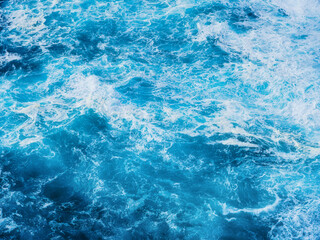 Waves as background. Huge ocean waves near the coast. Nature. Background and wallpaper in nature. Water surface as texture. Blue water and sea foam.