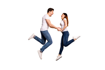 Full length side profile body size photo funky crazy she her he him his pair touch arms jumping high yell scream shout best buddies wear casual jeans denim white t-shirts isolated yellow background