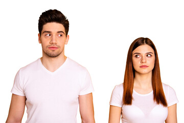 Fototapeta premium Close up photo two amazing beautiful she her he him his couple standing side by side look each other not smile tell talk speak say wear casual white t-shirts outfit clothes isolated yellow background