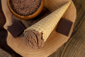 chocolate ice cream in a cone on a board