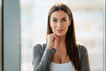 Fototapeta premium Brunette haired businesswoman standing in a modern office
