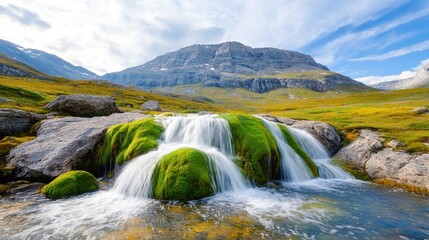 Obraz premium The natural waterfall cascades down a series of moss covered rocks, creating a stunning contrast of vibrant green against the smooth gray stone.