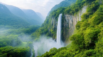 Fototapeta premium Madakaripura Waterfall stands as a majestic natural wonder, cascading down from the lush green forest canopy with an awe inspiring height that captures the beauty and power of nature.