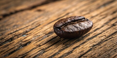 Obraz premium A single roasted coffee bean rests on a rustic wooden surface, showcasing its rich brown color and intricate texture.