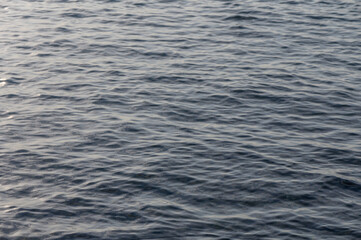 Calm waves reflecting soft light during a serene sunset over a tranquil ocean