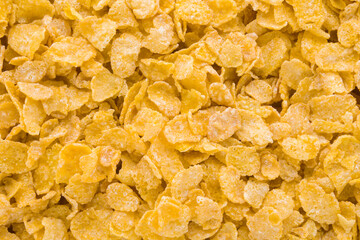 Yellow dry corn flakes background. Closeup. Top down view.