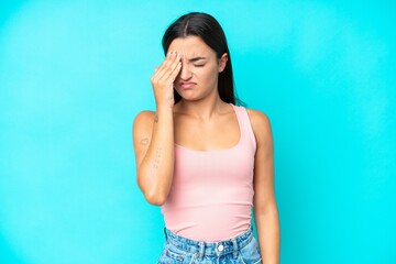 Young caucasian woman isolated on blue background with headache