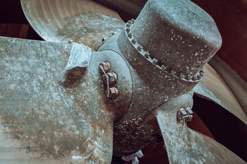 Close up of a ships variable pitch propeller in dry dock, covered in marine growth.