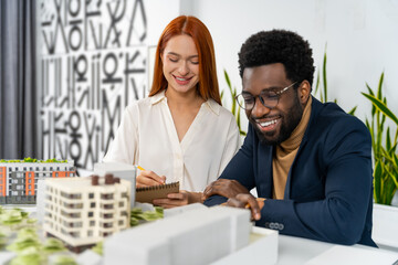Two colleagues sitting at the table in the office and discussing something