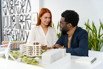 Two colleagues sitting at the table in the office and discussing something